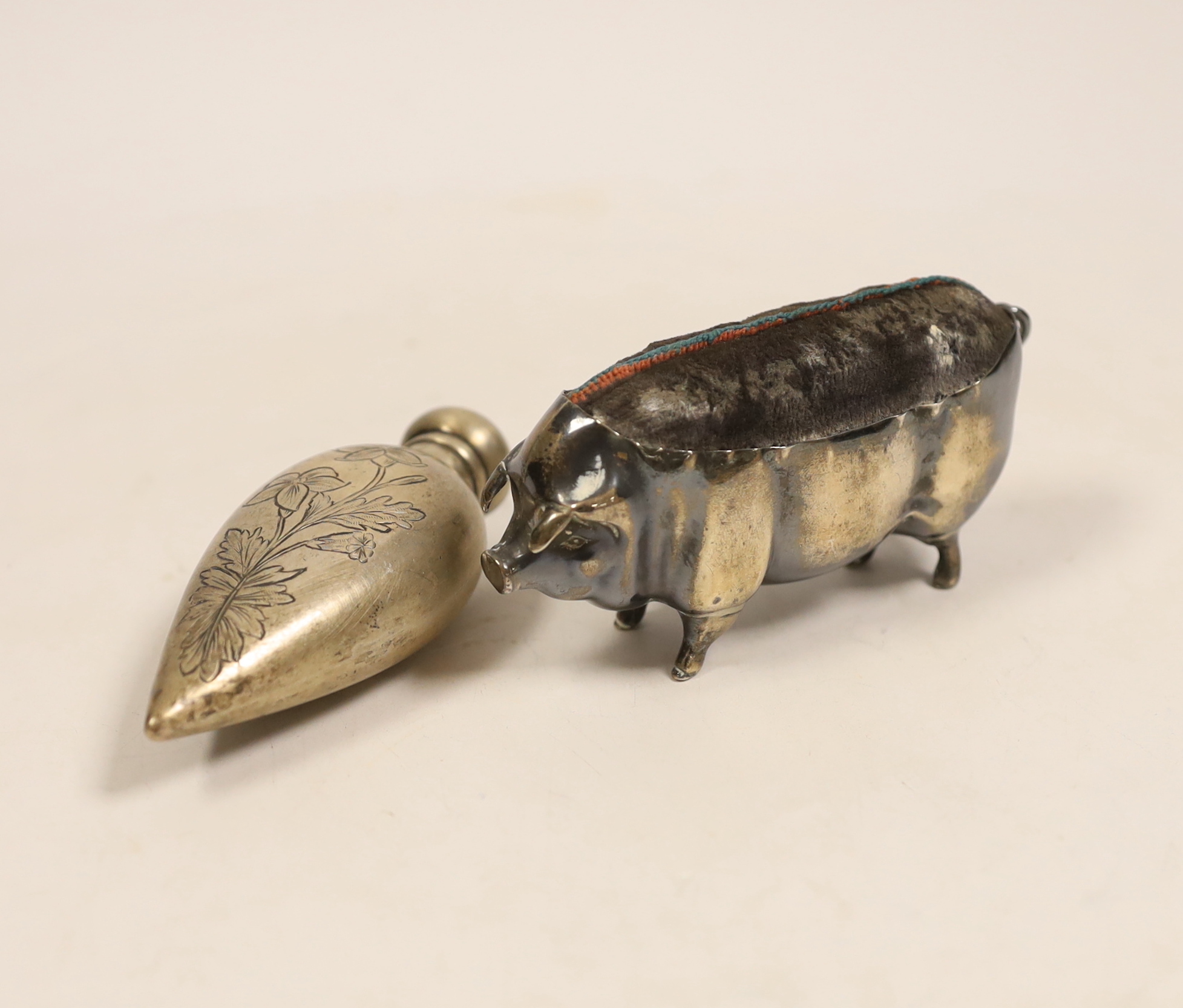 A large Edwardian silver mounted pig pin cushion, Levy & Salaman, Birmingham, 1904, length 10.5cm, together with a scent bottle.